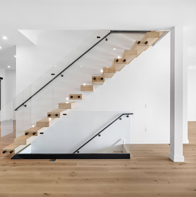 Floating oak stair with glass balustrade and black handrail