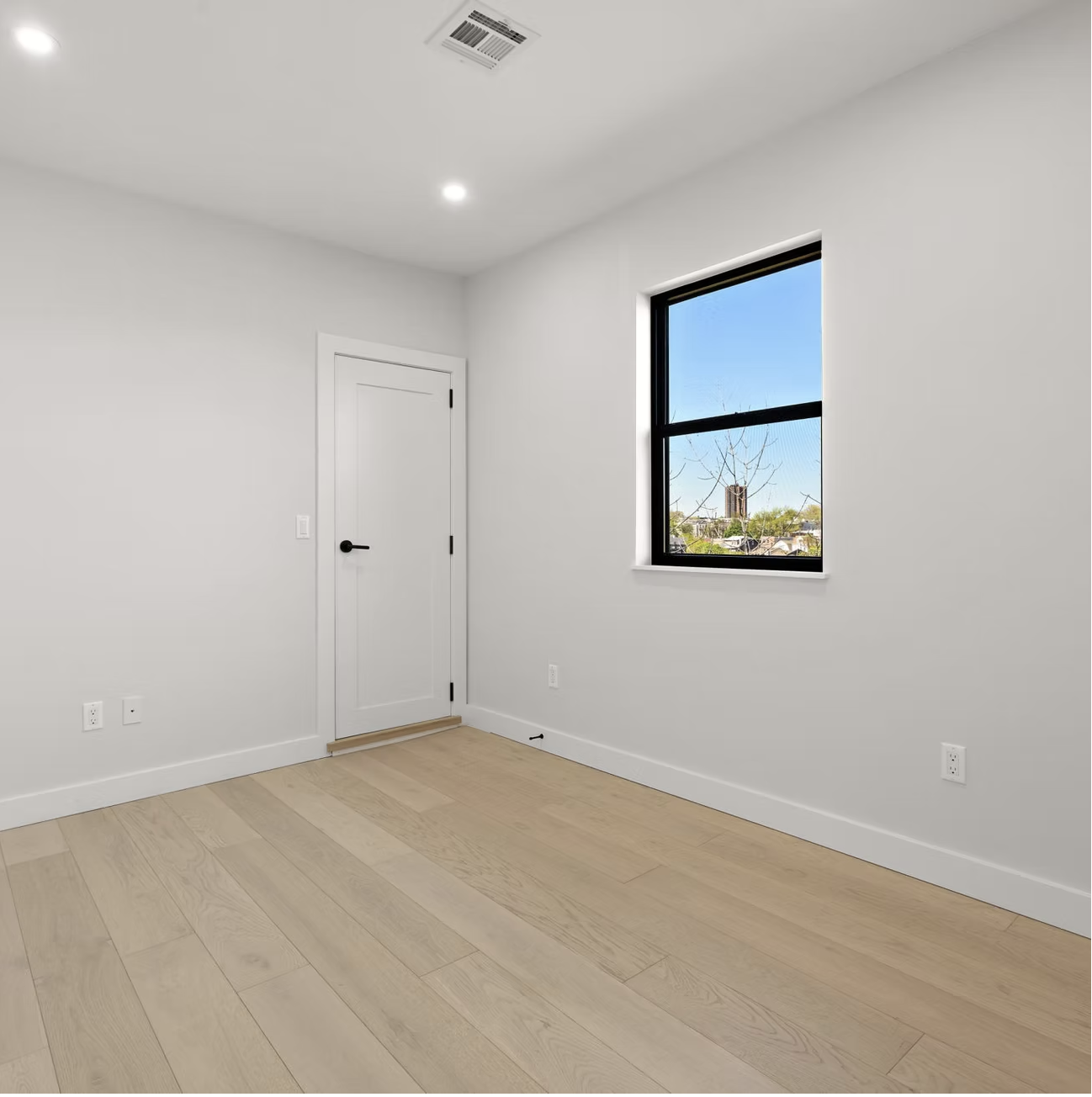 Bedroom with tall window and rooftop views