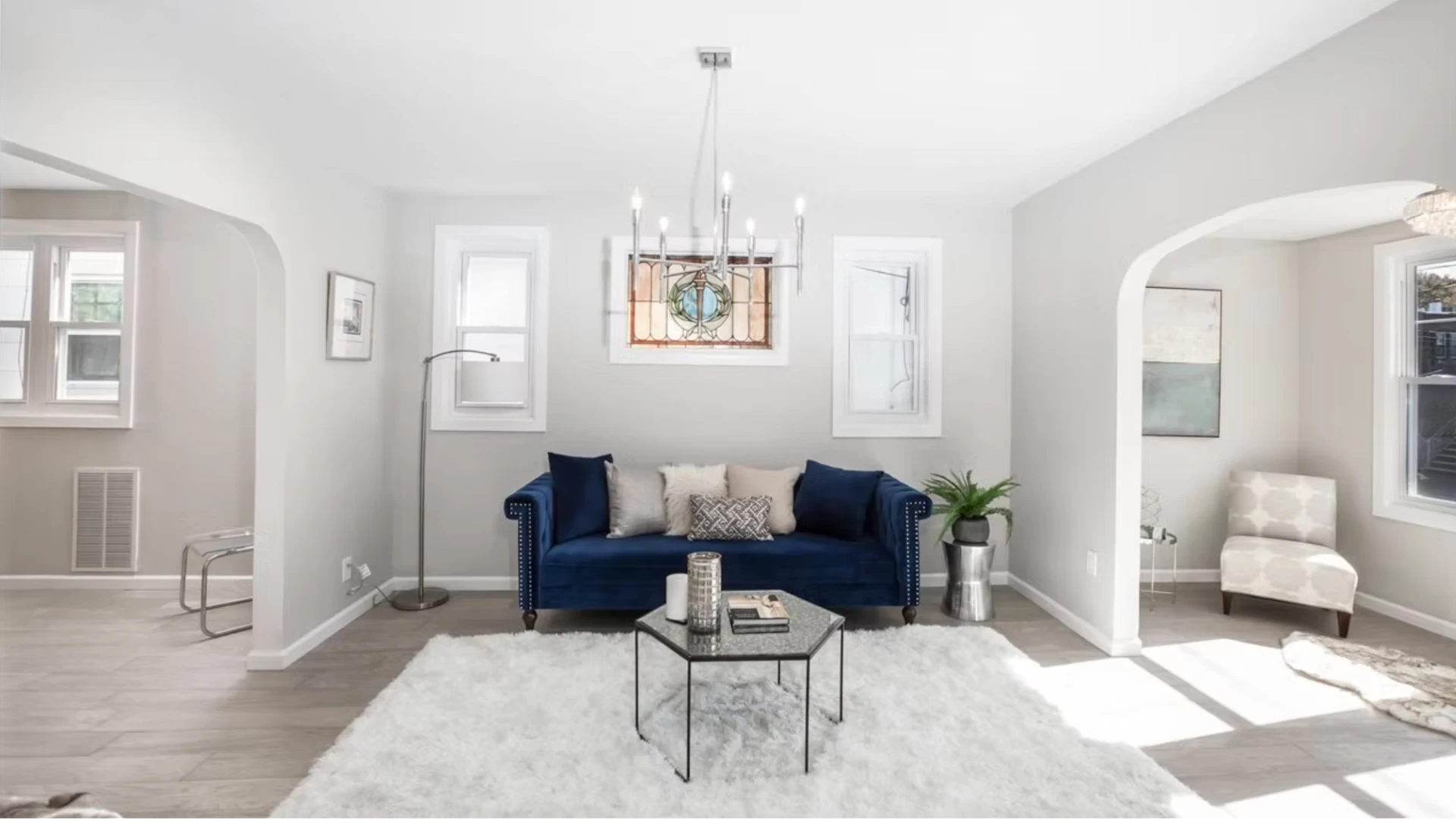 Open reception room with arched openings and restored stained glass window