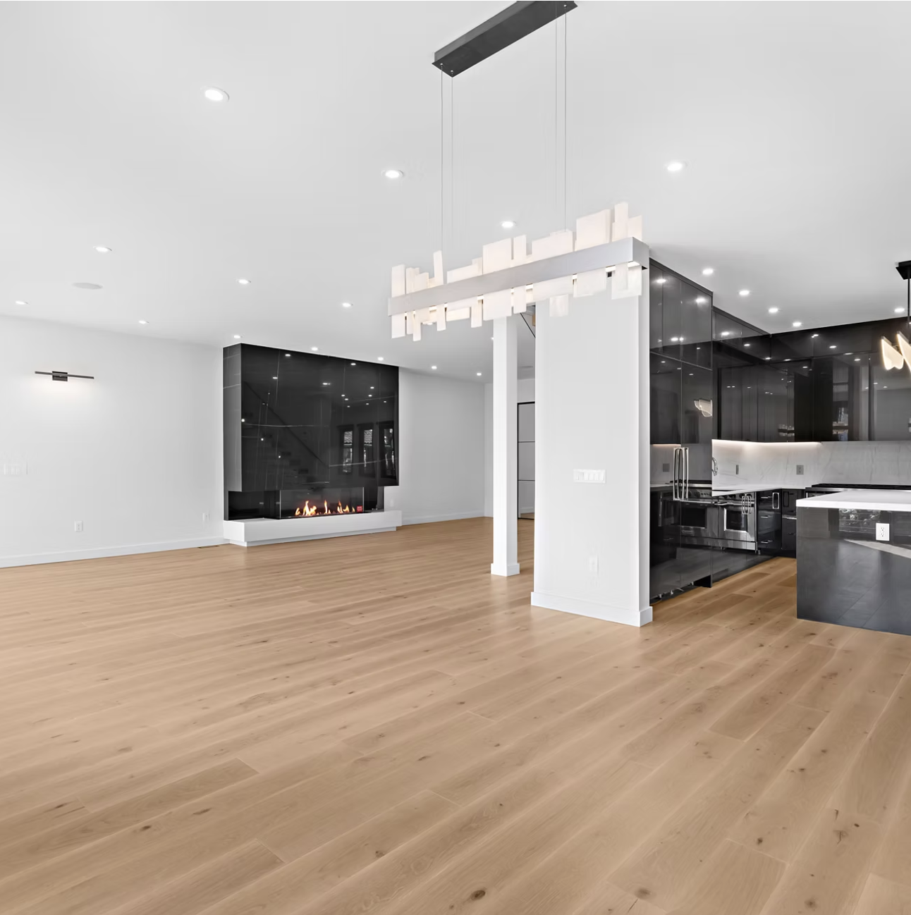 Living and kitchen space with linear pendant lighting