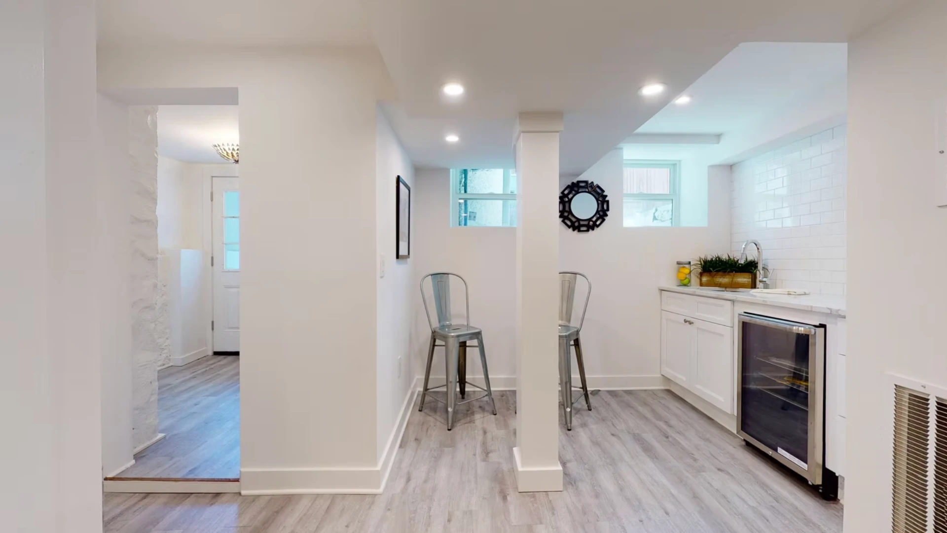 Lower ground bar area with white cabinetry, wine fridge and metro tiling