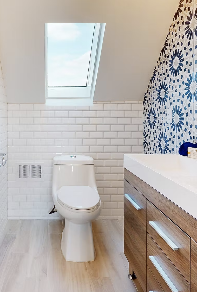 Cloakroom with skylight, white metro tiling and patterned feature wall
