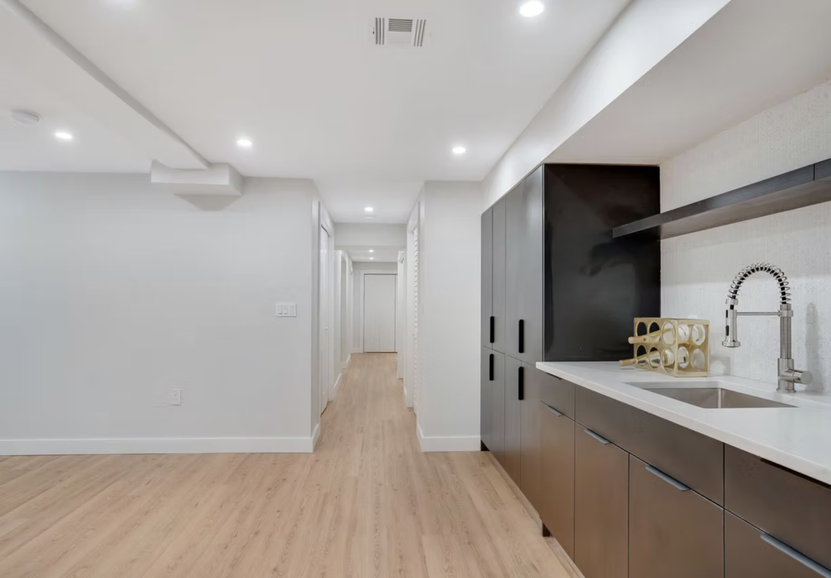 Hallway with utility bar, dark cabinetry and stone worktop