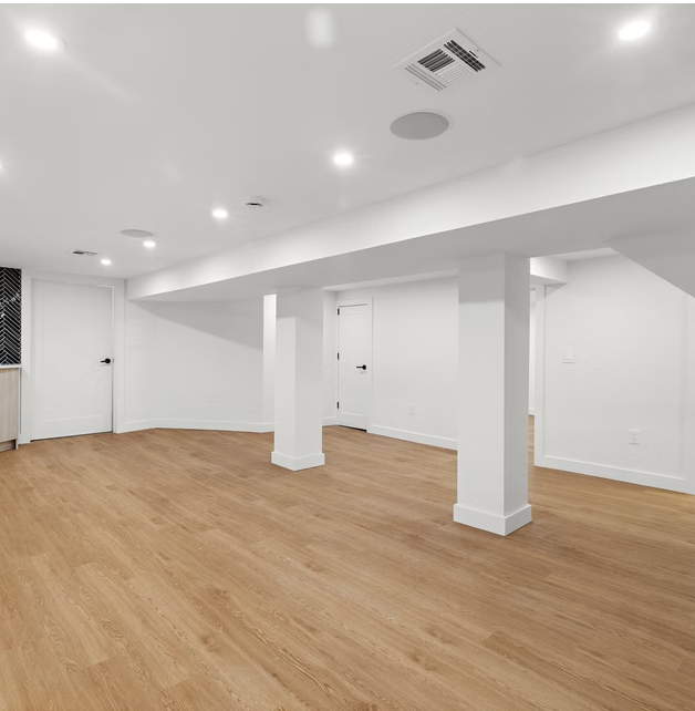 Lower ground floor room with oak flooring and white columns