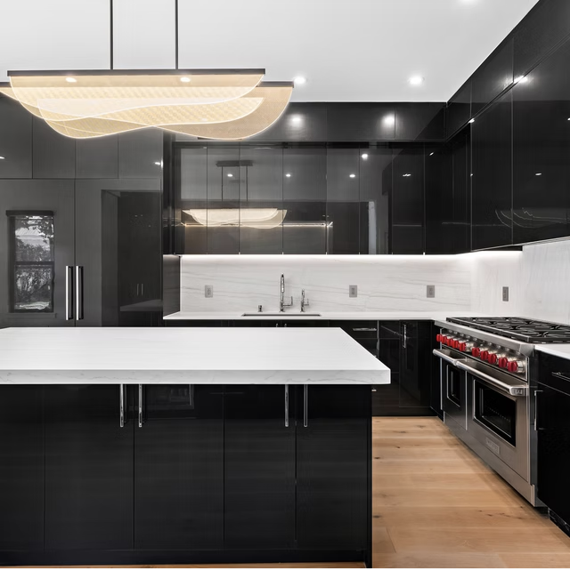 Black kitchen joinery with marble worktops and range cooker