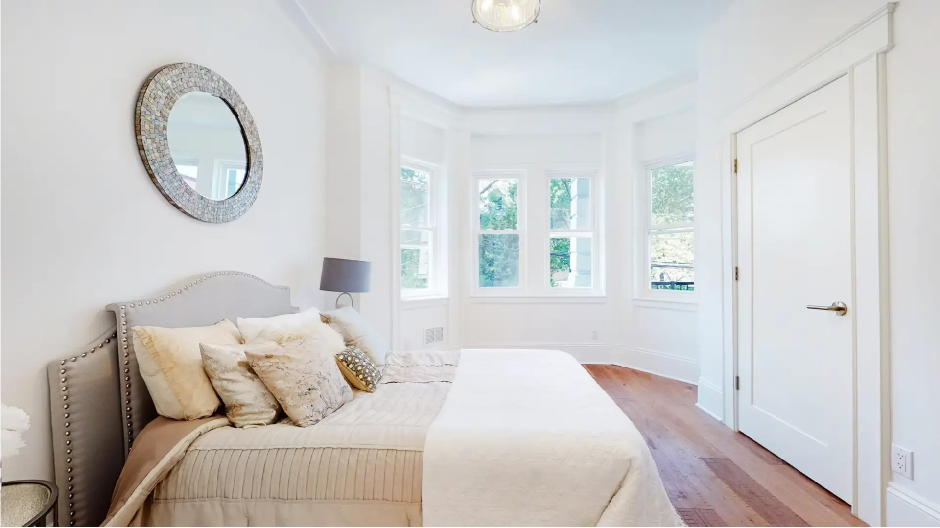 Principal bedroom with bay windows and restored hardwood flooring