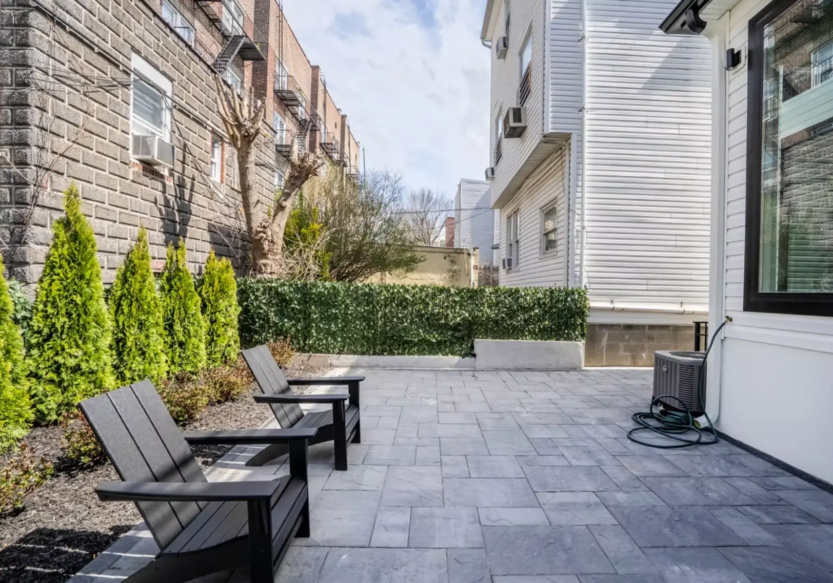 Side courtyard with stone paving and garden seating