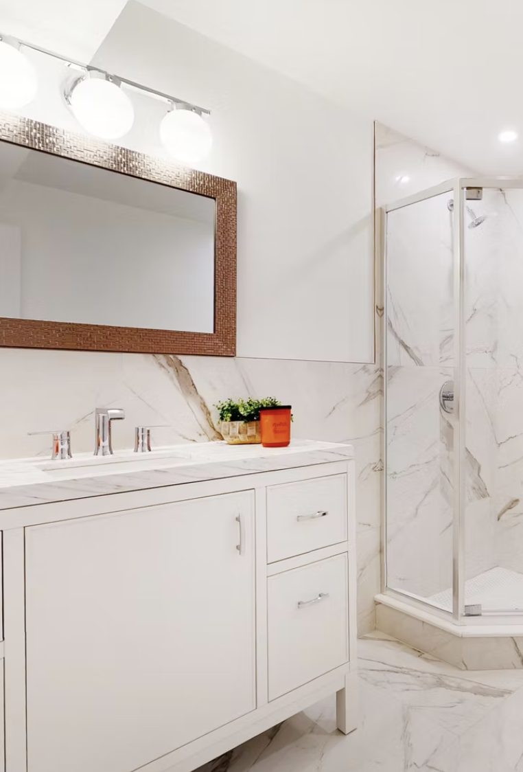 Marble bathroom with fitted vanity and corner shower enclosure