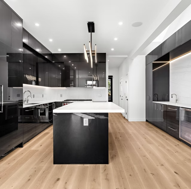 Gloss black kitchen with marble island and pendant lights