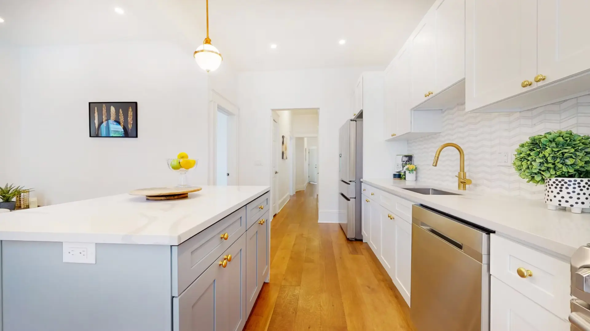 Shaker kitchen with stone worktops, brass fittings and integrated appliances