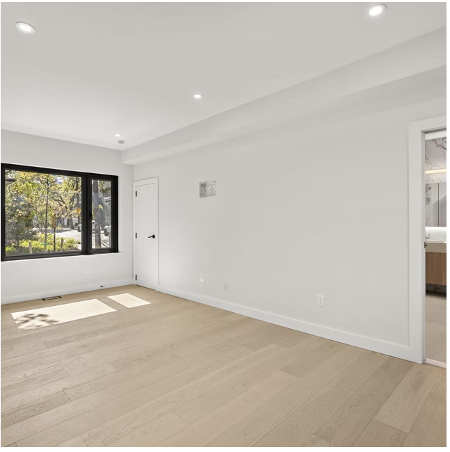 Principal bedroom with black framed window and en suite beyond
