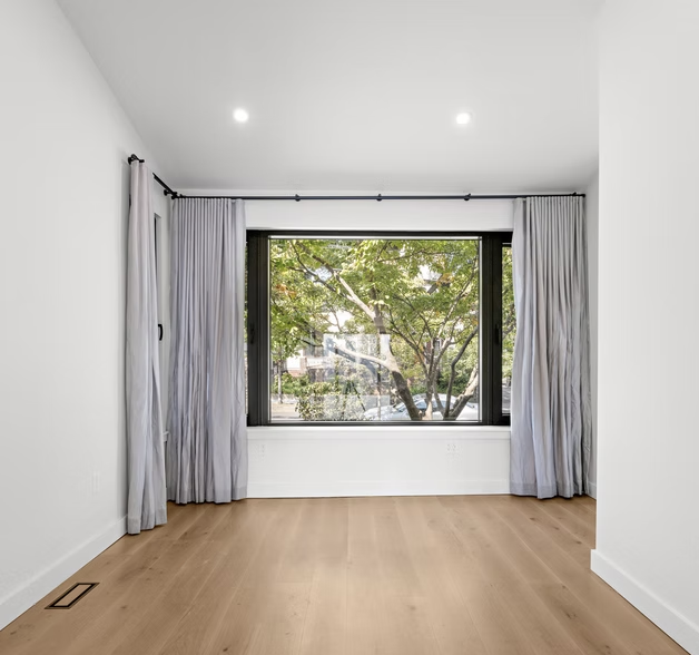 Bedroom with wide picture window and curtains