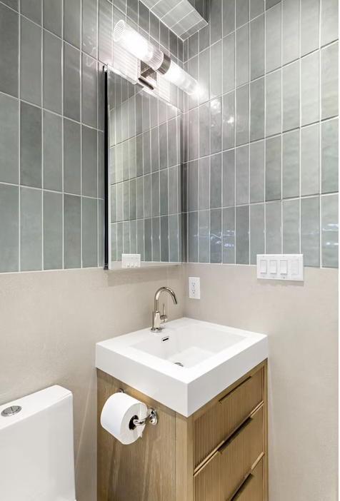 Cloakroom with green tile, fluted timber vanity and mirrored cabinet