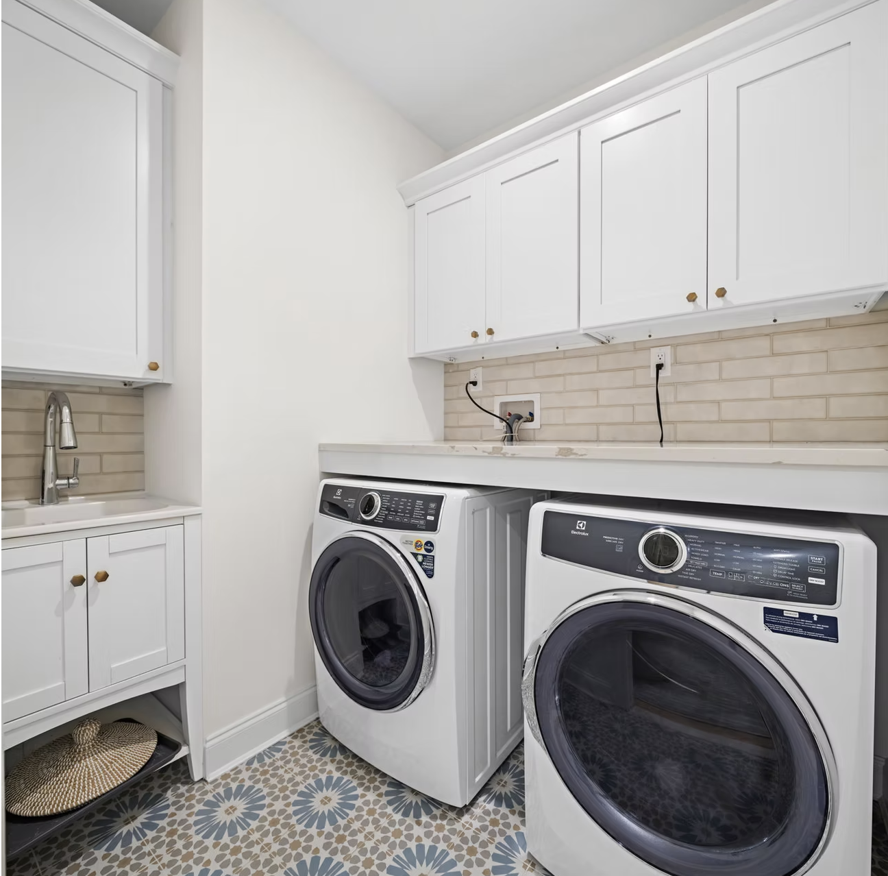 Utility room with white cabinetry, stone worktop and patterned floor tiles