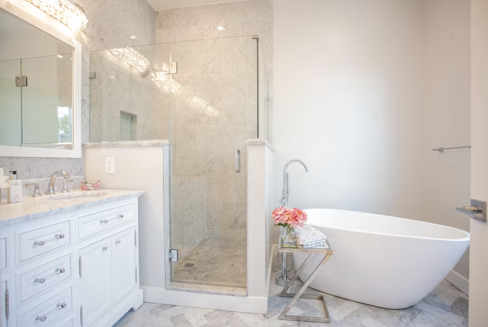 Marble bathroom with freestanding bath, glazed shower and fitted vanity