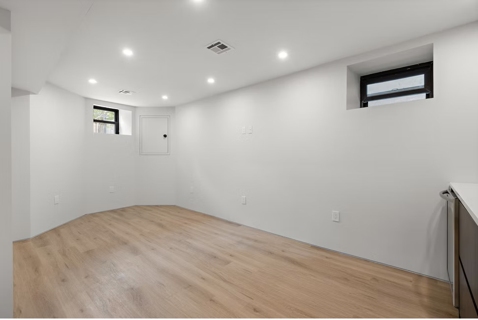 Lower ground room with oak flooring and black framed windows