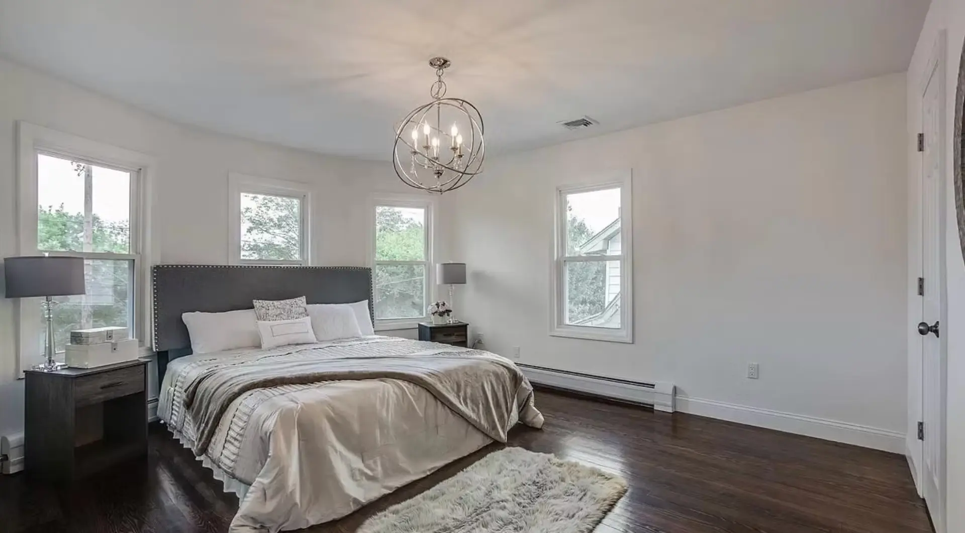 Principal bedroom with bay windows and dark oak flooring