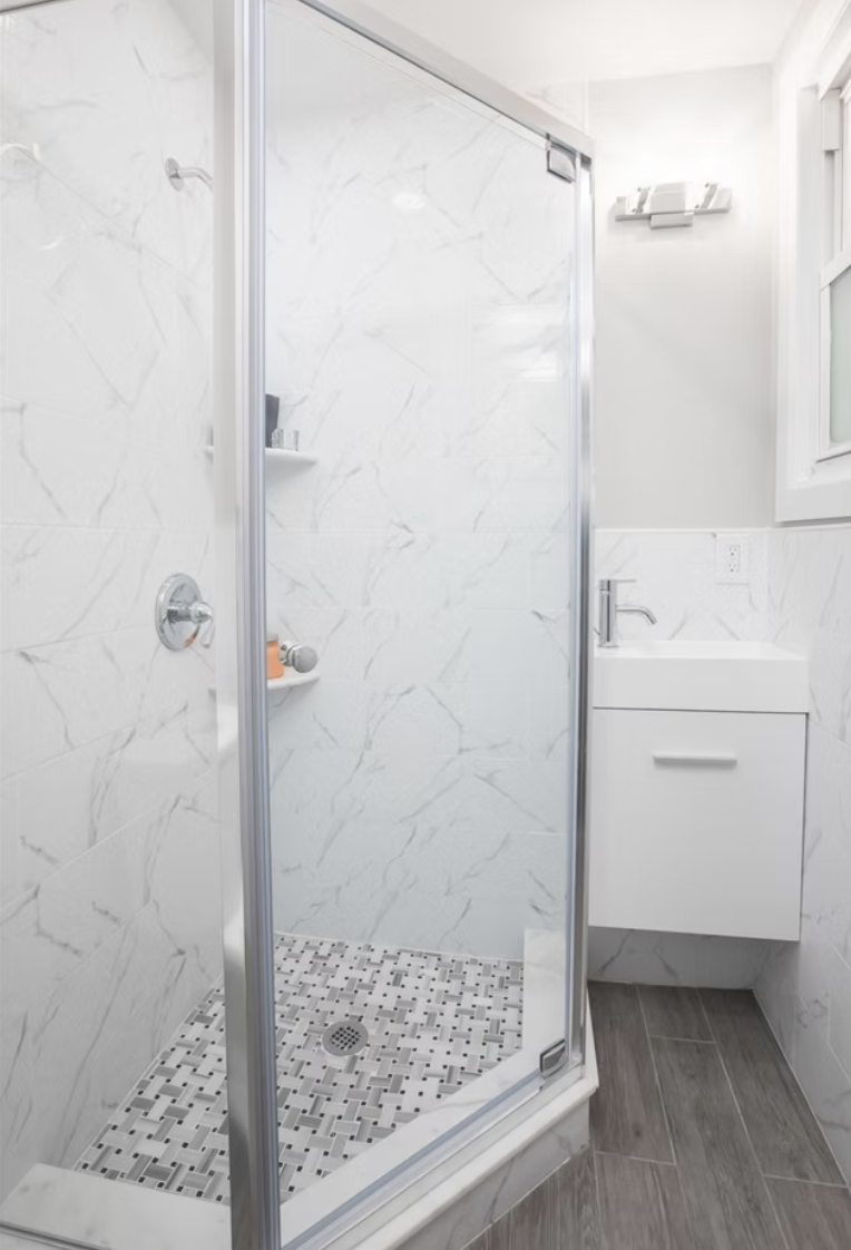 Shower room with marble effect tiling and wall hung vanity