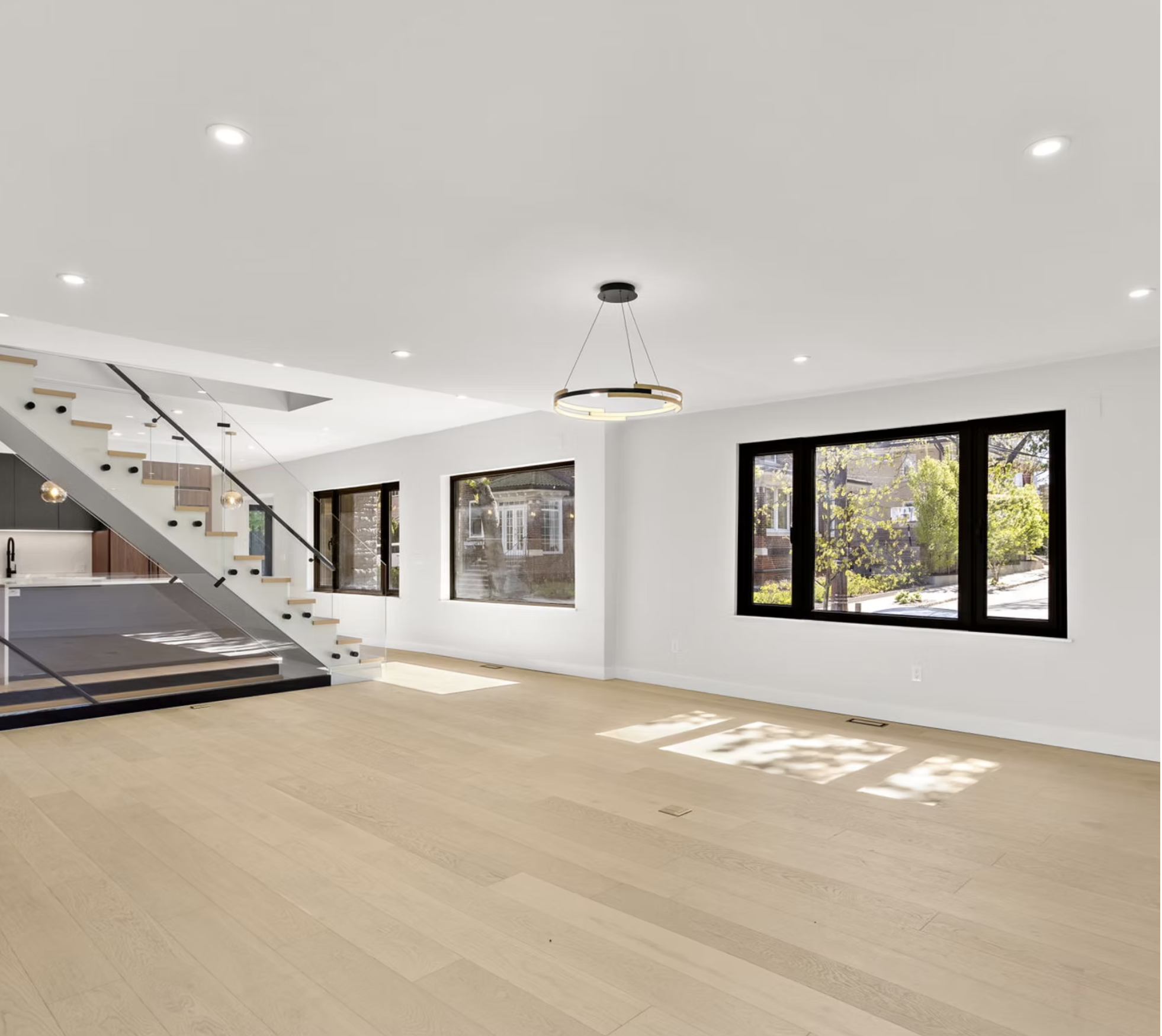 Wide reception room with black framed windows and oak flooring