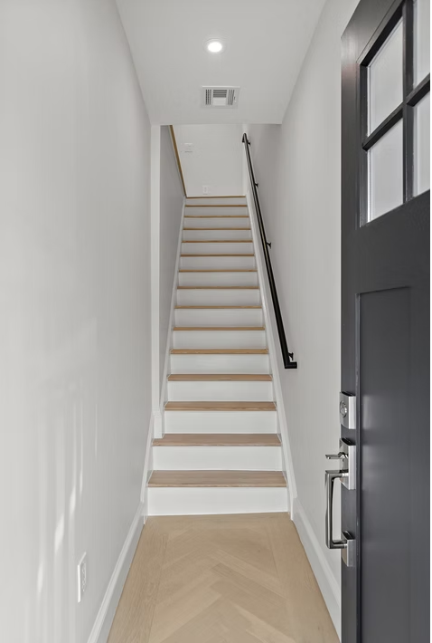 Entrance hall with herringbone flooring and oak stair
