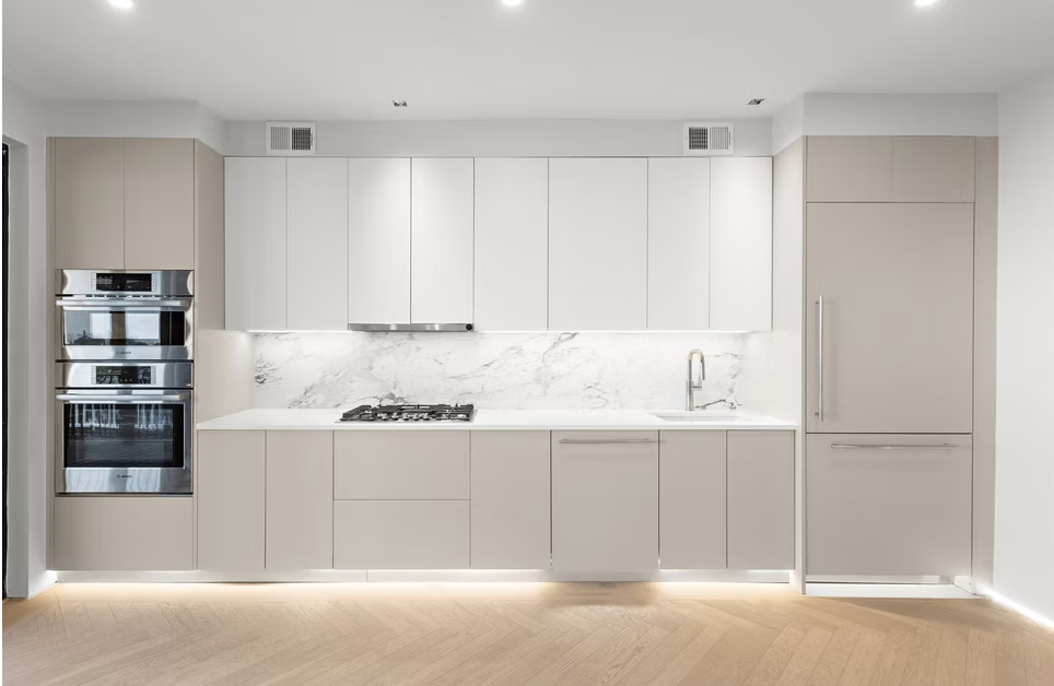 Handleless kitchen run with marble splashback and integrated ovens