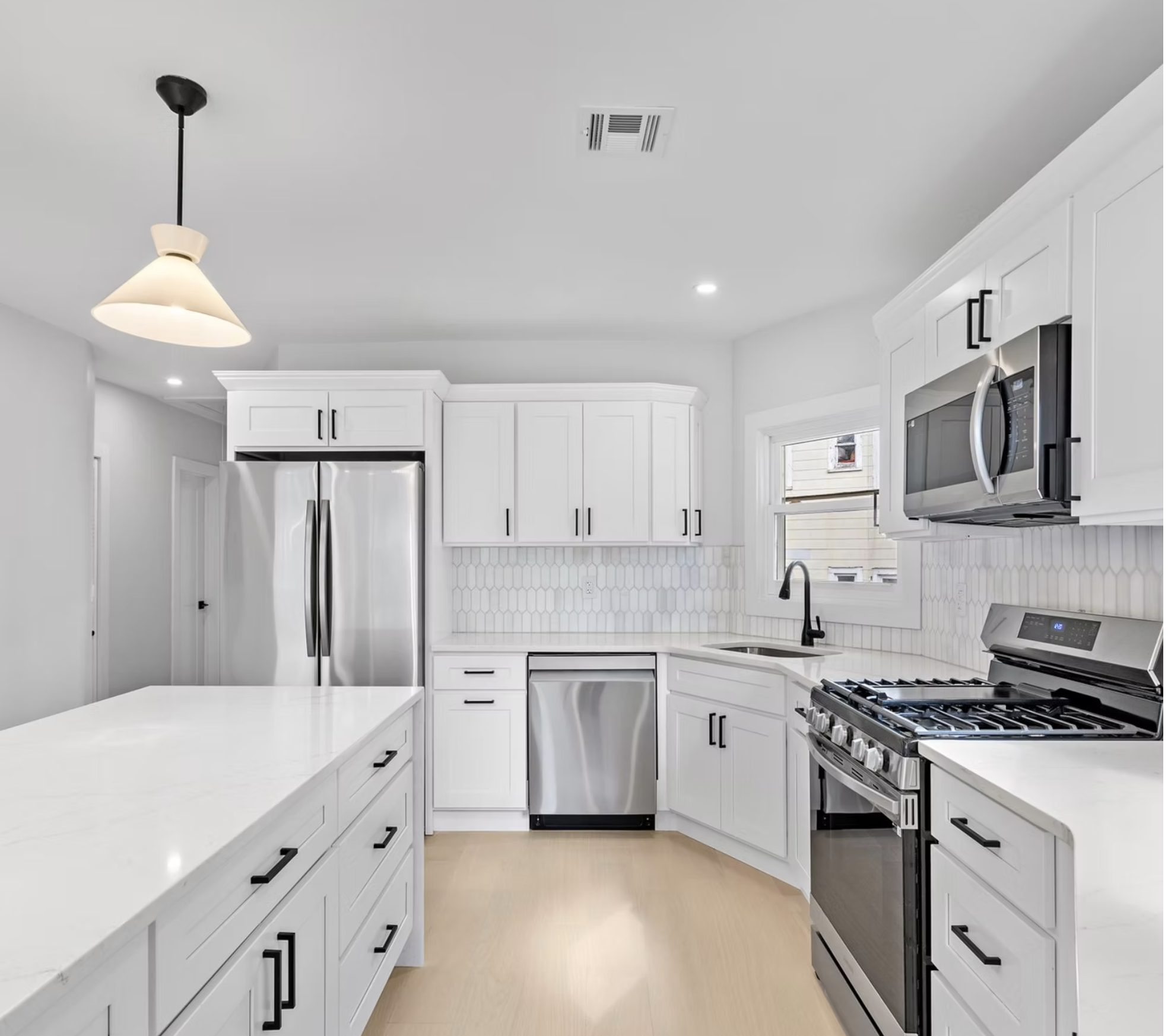 Kitchen with tiled splashback and integrated appliances