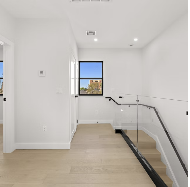 Upper landing with glass balustrade and oak flooring