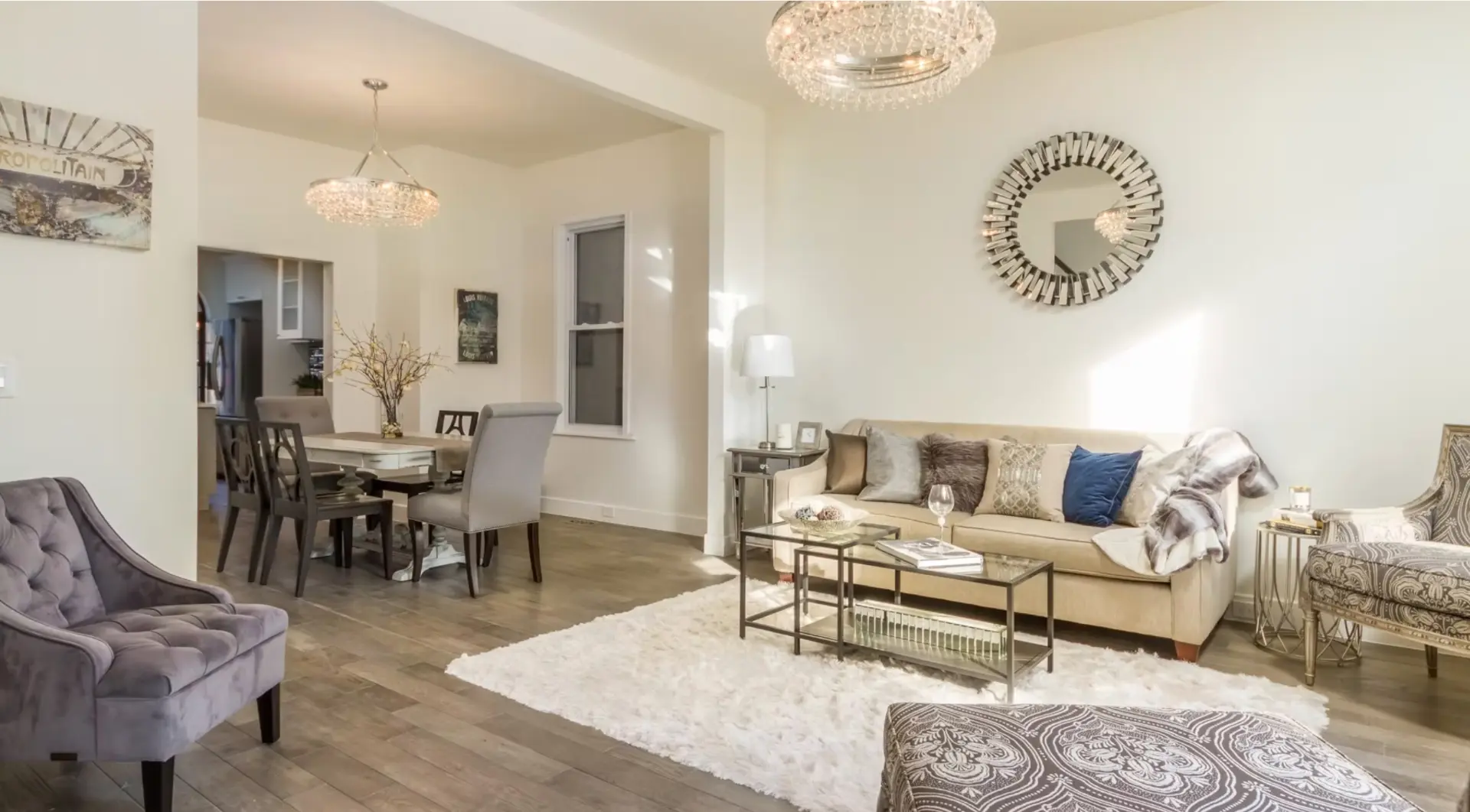 Living and dining space with crystal chandeliers and timber flooring