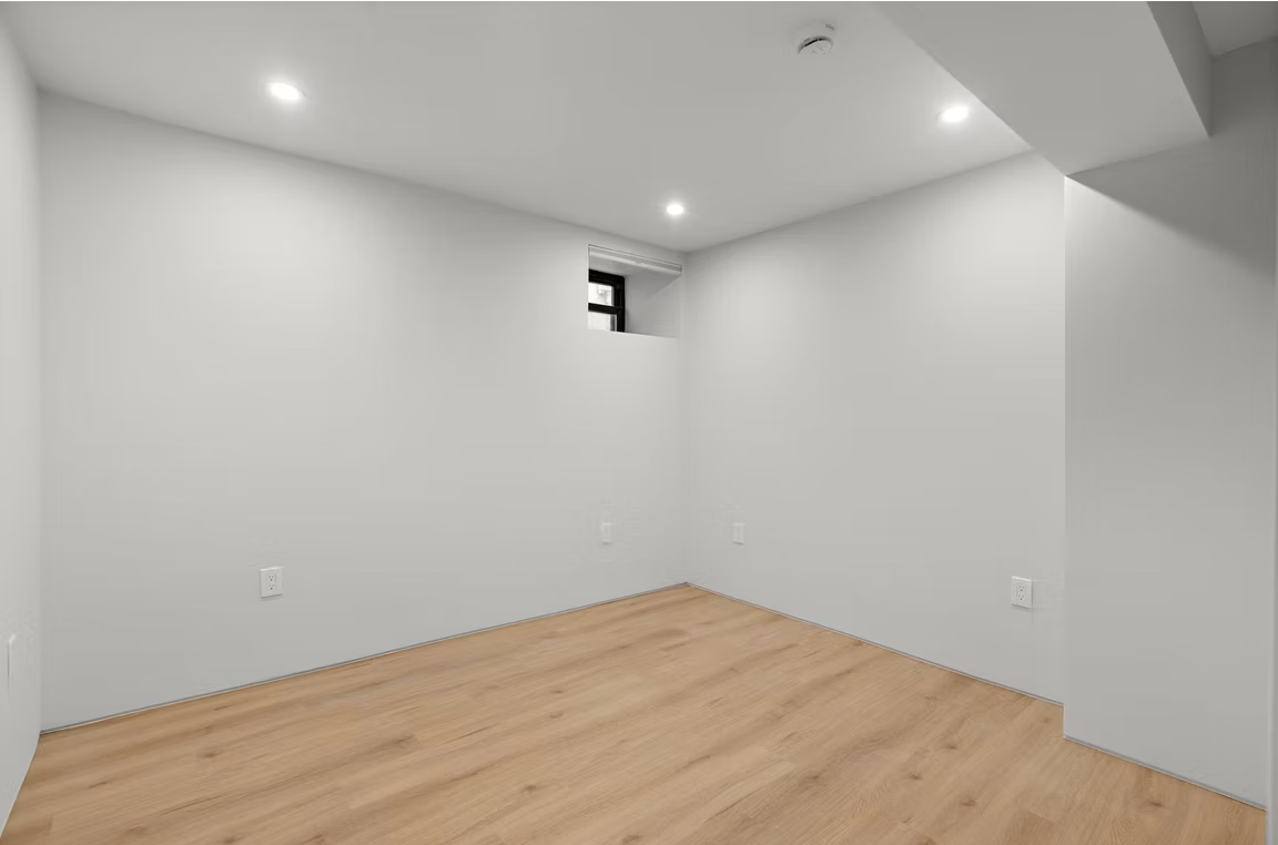 Lower ground room with oak flooring and high level window