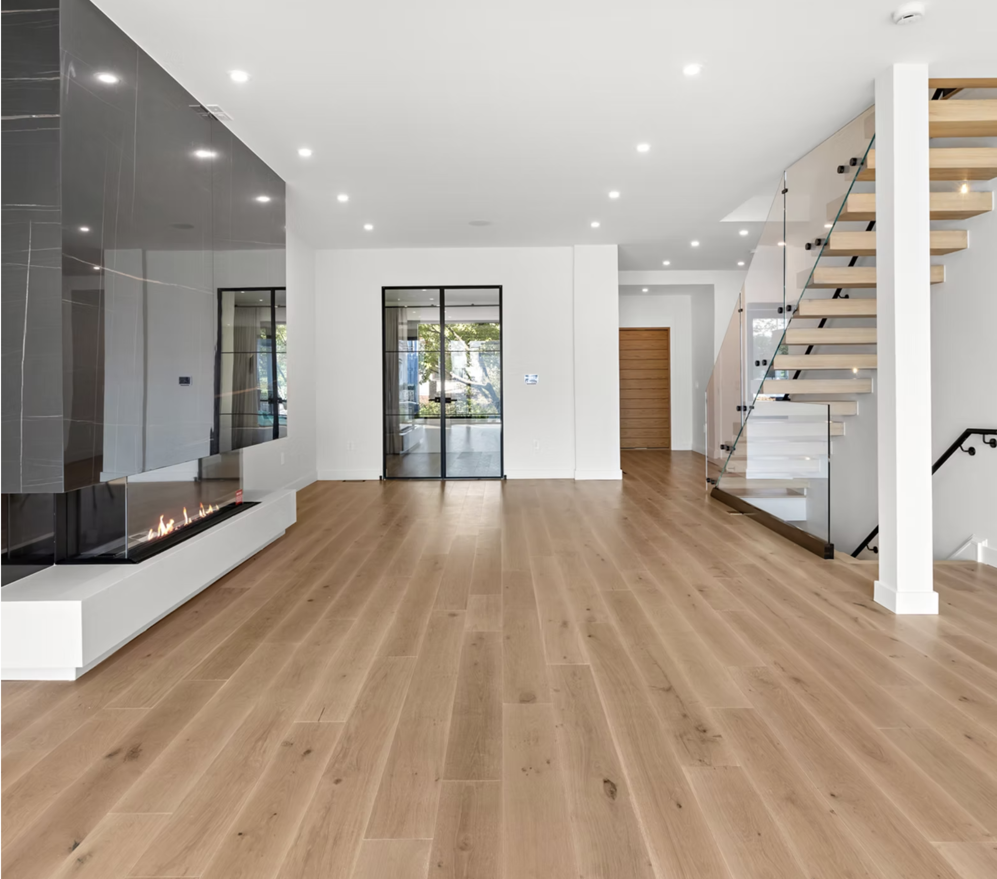Open living space with marble fireplace and open tread oak stair