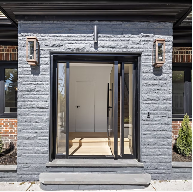 Stone framed entrance with glazed pivot door