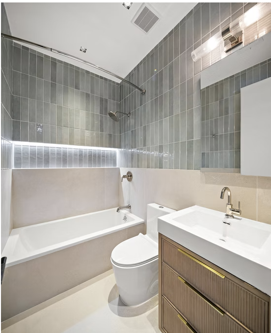 Bathroom with green tiled shower, bath and fluted timber vanity