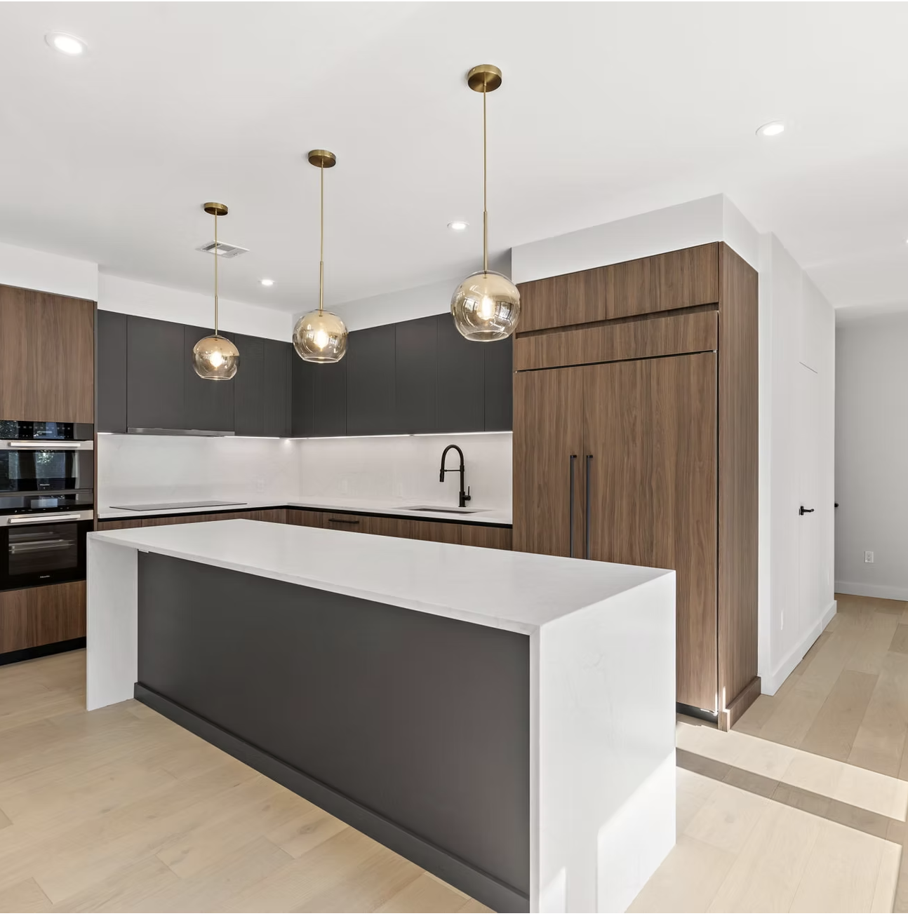 Kitchen with walnut joinery and brass pendant lighting