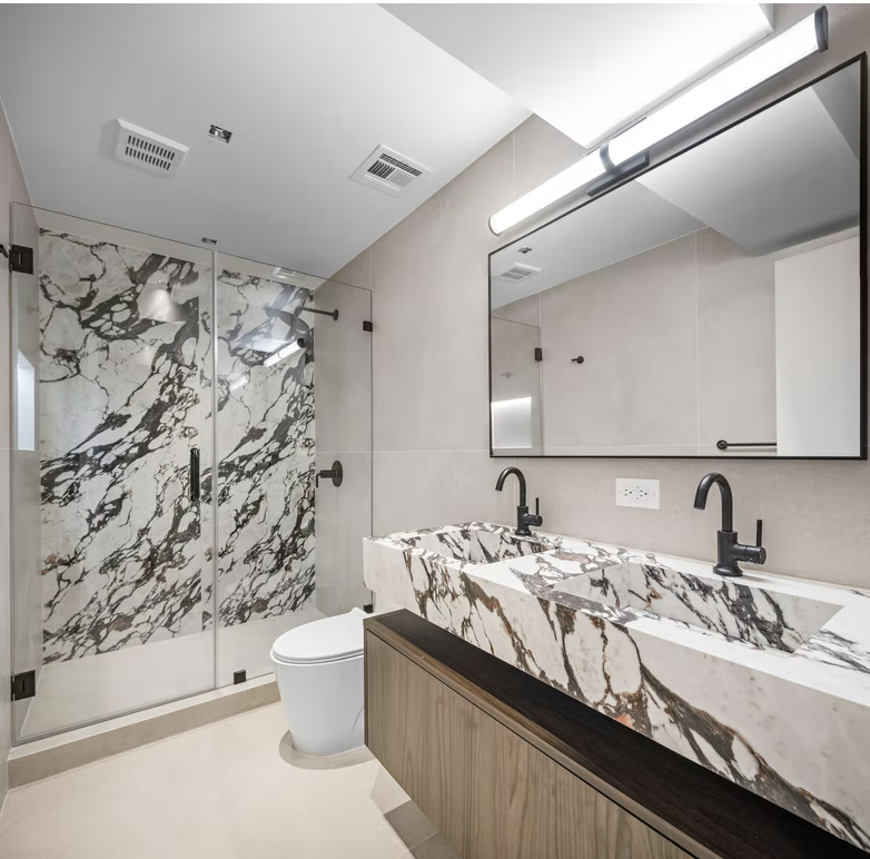 Bathroom with book matched marble shower and double marble vanity
