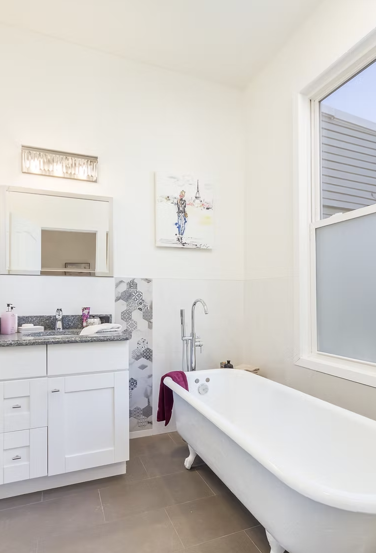 Bathroom with freestanding roll top bath and patterned tile detail