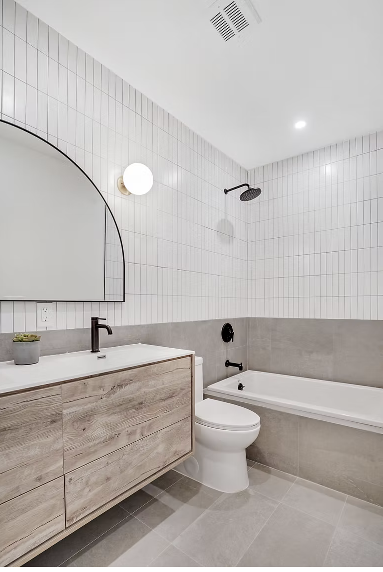 Family bathroom with bath, timber vanity and arched mirror