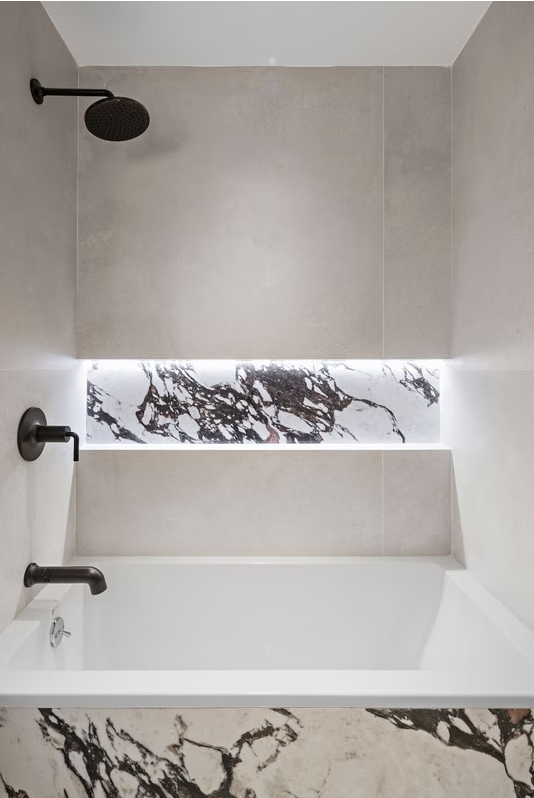 Bath with backlit marble niche and matt black fittings